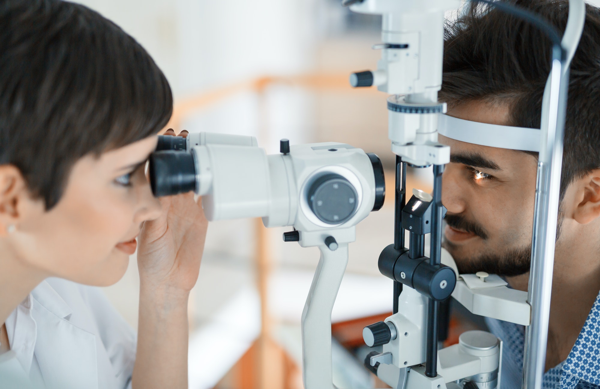 Woman doing eye test with optometrist in eye sight clinic